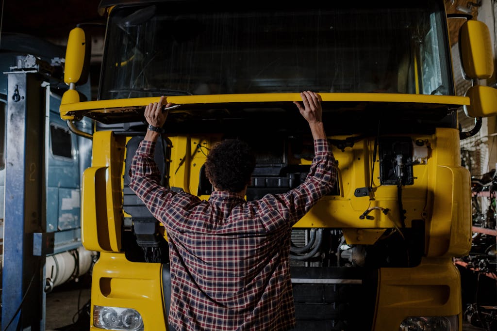 A Person Looking under the Hood of a Truck